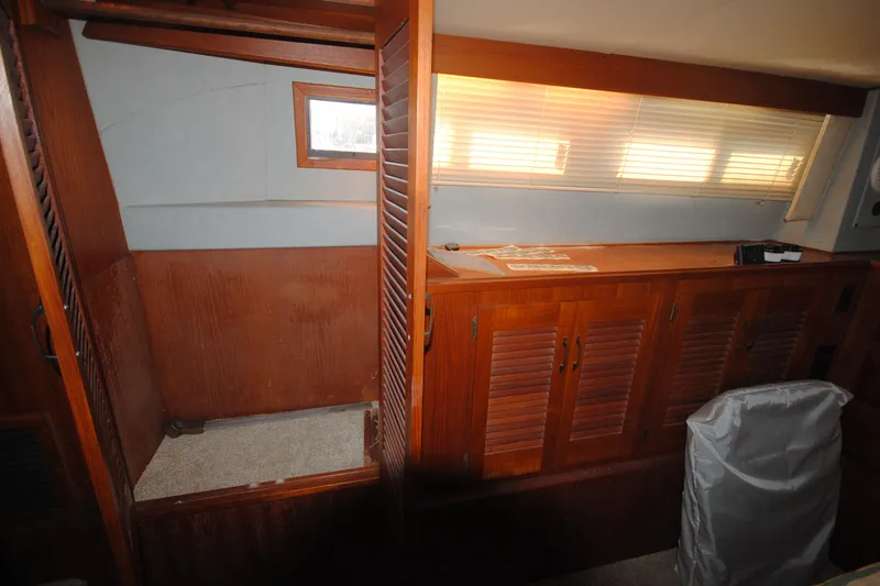Slide: The Image of 1986 Viking 50 Motor Yacht interior with wooden cabinets and window blinds. - 48