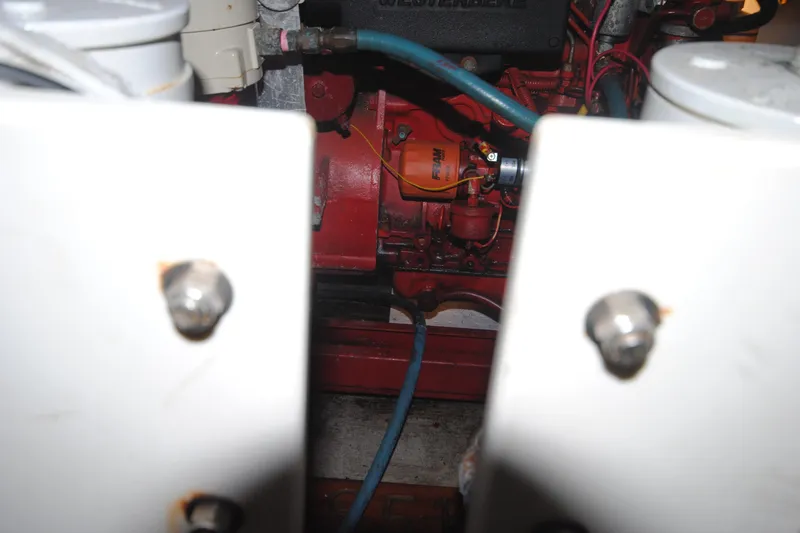 Slide: The Image of Engine compartment of a 1986 Viking 50 Motor Yacht, featuring red components and blue hoses. - 54