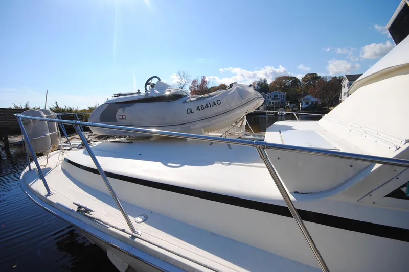 Slide: The Image of 1986 Viking 50 Motor Yacht with dinghy on deck, under clear blue sky. - 6