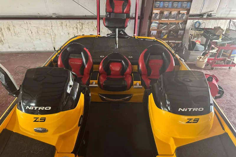 Slide: The Image of 2015 Nitro Z-9 DC boat interior with red and black seats in a garage setting. - 5