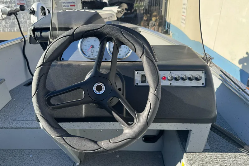 Slide: The Image of 2024 Lund 1400 Fury SS boat dashboard with steering wheel and control panel. - 10