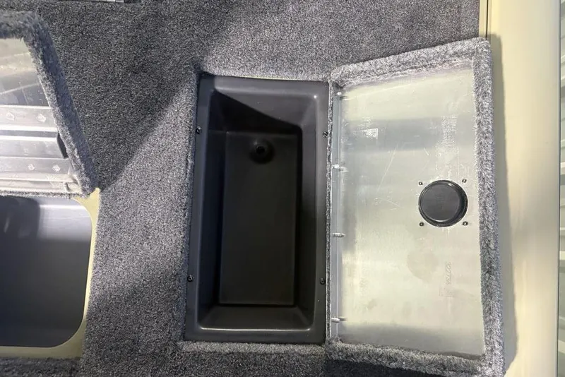 Slide: The Image of Open storage compartment in 2026 Tracker Pro Team 175 boat, featuring carpeted interior. - 30