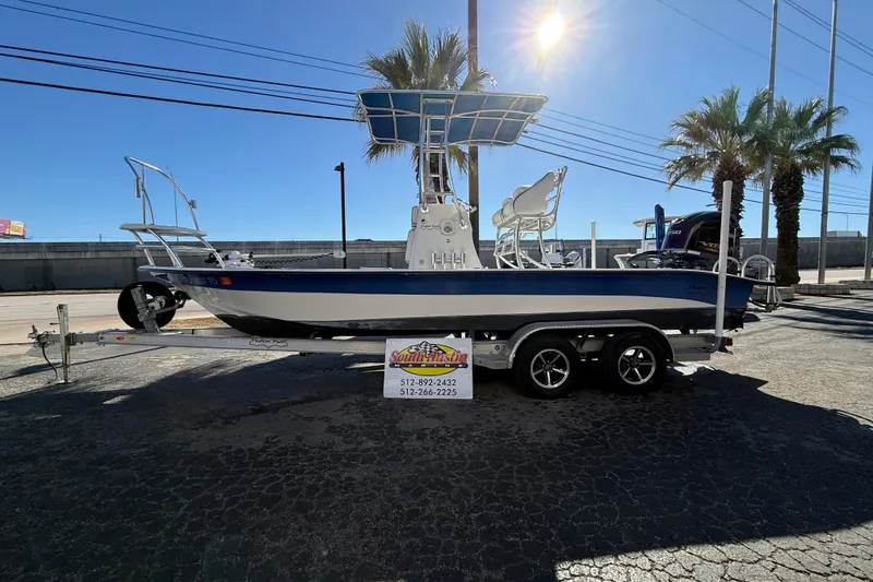 Slide: The Image of 2018 Shallow Sport 24 Modified V boat on trailer, sunny day, palm trees in background. - 15