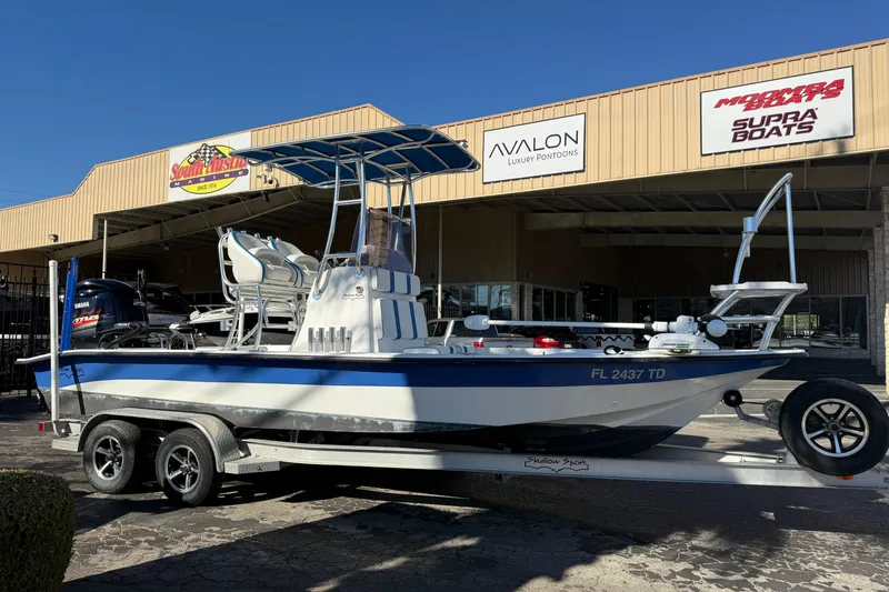 Slide: The Image of 2018 Shallow Sport 24 Modified V boat on trailer outside dealership. - 18