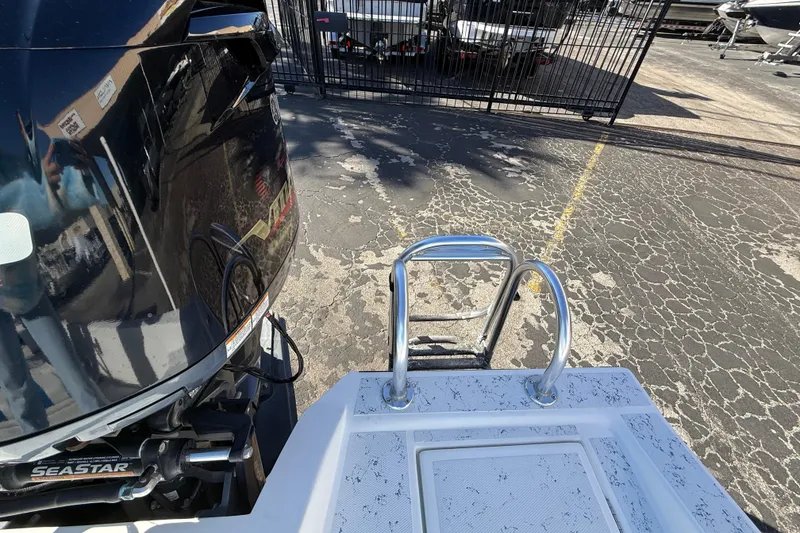 Slide: The Image of 2018 Shallow Sport 24 Modified V boat with ladder and motor in parking lot. - 23