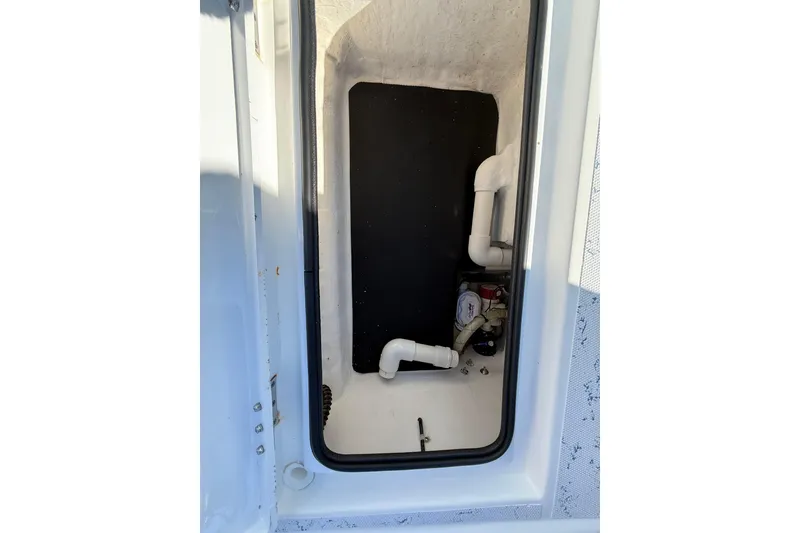 Slide: The Image of 2018 Shallow Sport 24 Modified V boat compartment with plumbing and storage. - 26