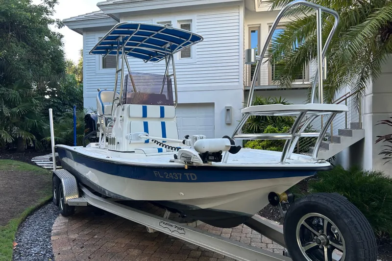Slide: The Image of 2018 Shallow Sport 24 Modified V boat on trailer, parked in front of a house. - 3
