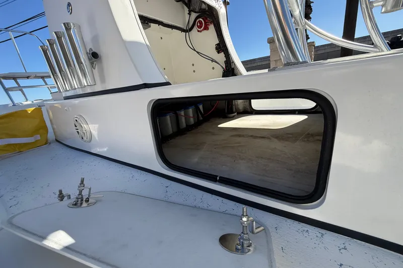 Slide: The Image of 2018 Shallow Sport 24 Modified V boat interior, featuring storage compartment and rod holders. - 31