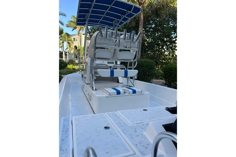 Slide: The Image of 2018 Shallow Sport 24 Modified V boat with blue-striped seating and canopy. - 4