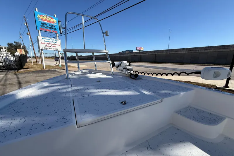 Slide: The Image of 2018 Shallow Sport 24 Modified V boat on display at dealership, clear sky background. - 48