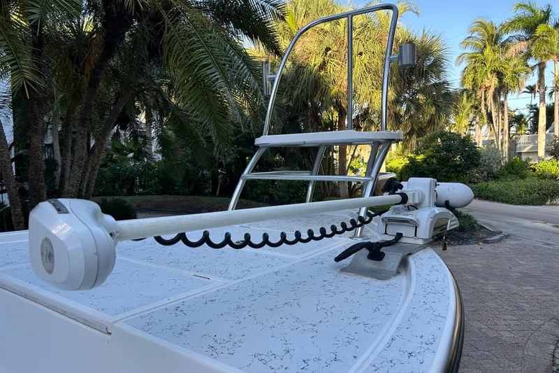 Slide: The Image of 2018 Shallow Sport 24 Modified V boat with trolling motor, surrounded by palm trees. - 9