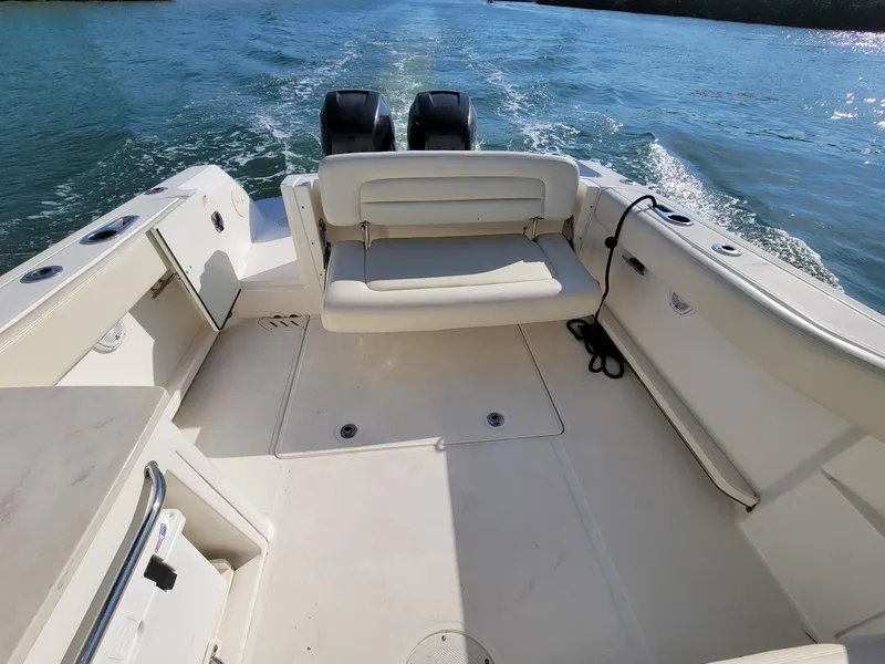 Slide: The Image of 2015 Boston Whaler 270 Vantage boat interior with seating and twin engines on water. - 6