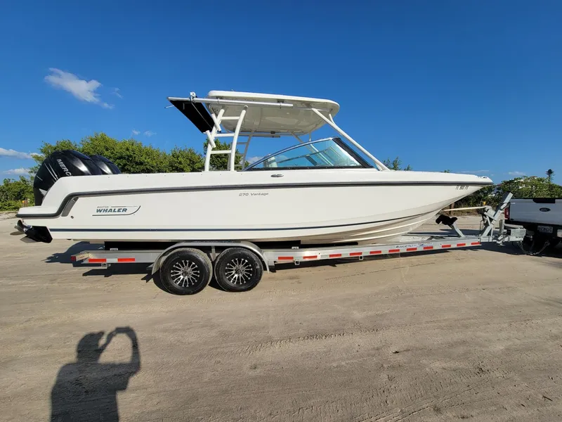 Slide: The Image of 2015 Boston Whaler 270 Vantage boat on trailer under clear blue sky. - 8