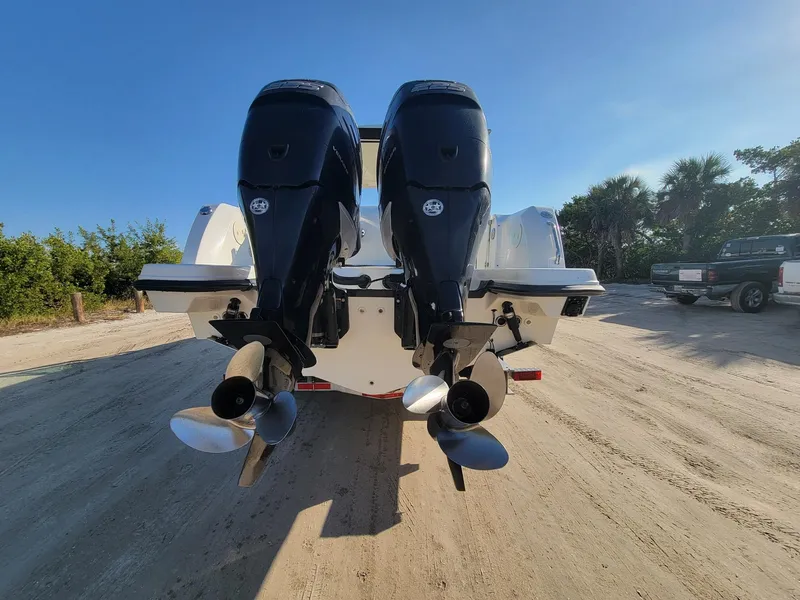 Slide: The Image of 2015 Boston Whaler 270 Vantage with dual outboard motors on a sandy shore. - 9