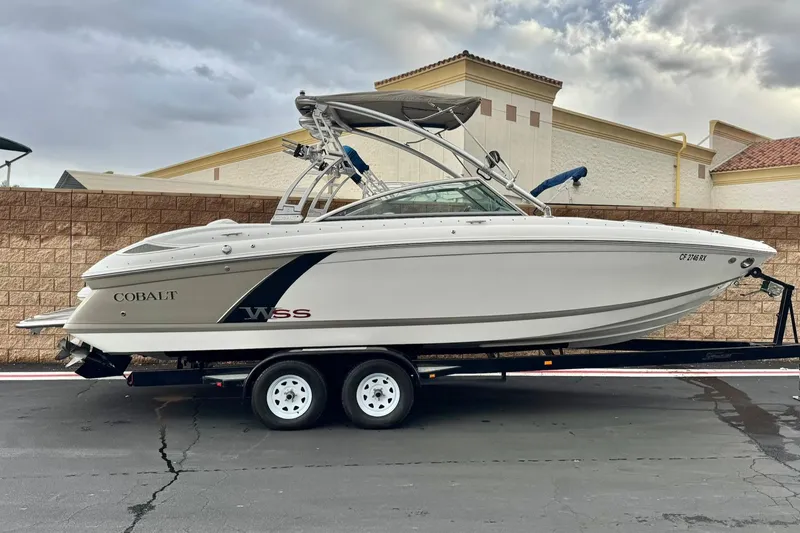 The Image of 2014 Cobalt 262 WSS boat on trailer, parked outdoors, overcast sky. - 0