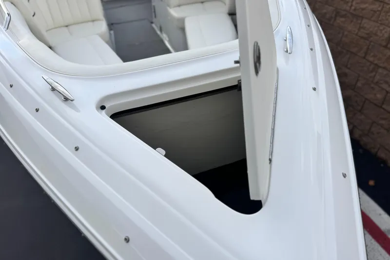Slide: The Image of 2014 Cobalt 262 WSS boat with open storage compartment and white seating. - 16
