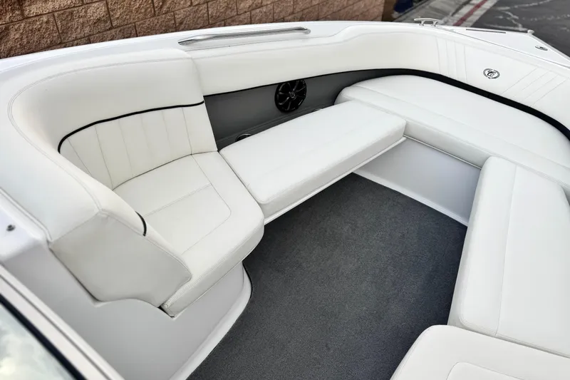 Slide: The Image of 2014 Cobalt 262 WSS boat interior with white cushioned seating and carpeted floor. - 19