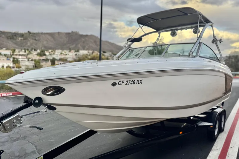 Slide: The Image of 2014 Cobalt 262 WSS boat on trailer, parked with scenic mountain backdrop. - 3