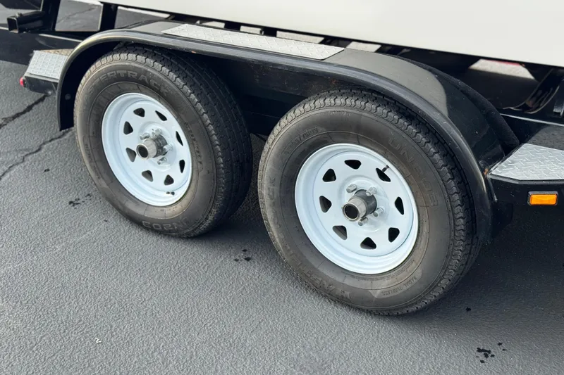 Slide: The Image of Trailer wheels of a 2014 Cobalt 262 WSS boat on pavement. - 30