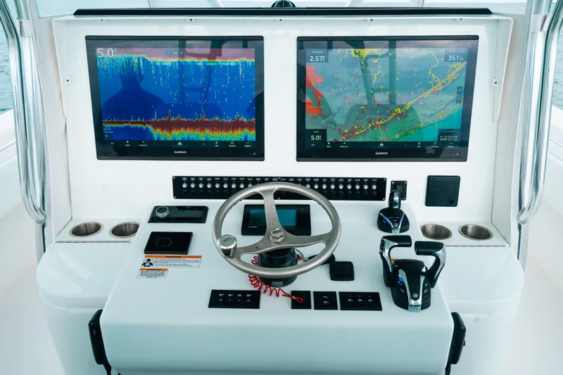 Slide: The Image of 2021 Contender 44 ST boat dashboard with dual Garmin displays and steering wheel. - 13