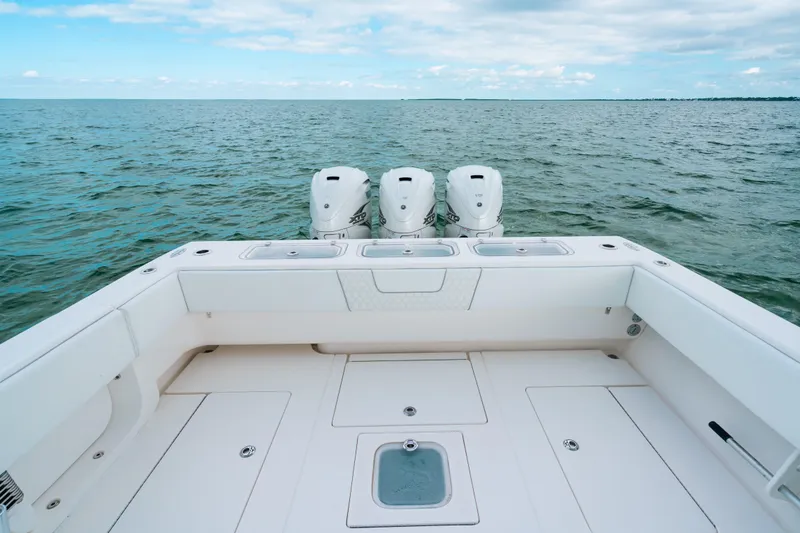 Slide: The Image of 2021 Contender 44 ST boat with triple outboard engines on open water. - 15