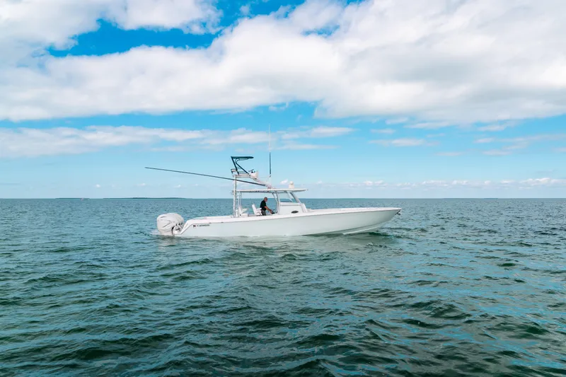 Slide: The Image of 2021 Contender 44 ST boat cruising on open water under a blue sky. - 2