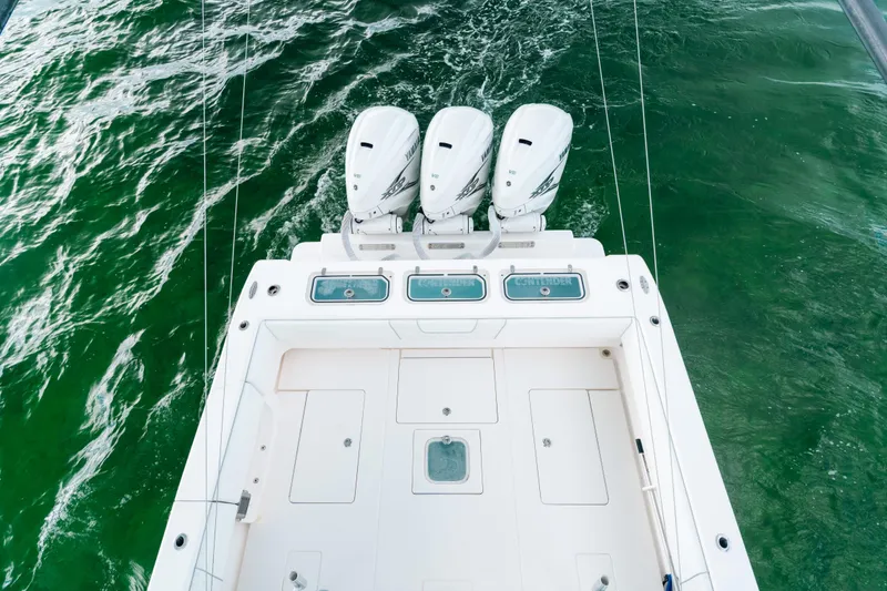 Slide: The Image of 2021 Contender 44 ST boat with triple outboard engines on green water. - 26
