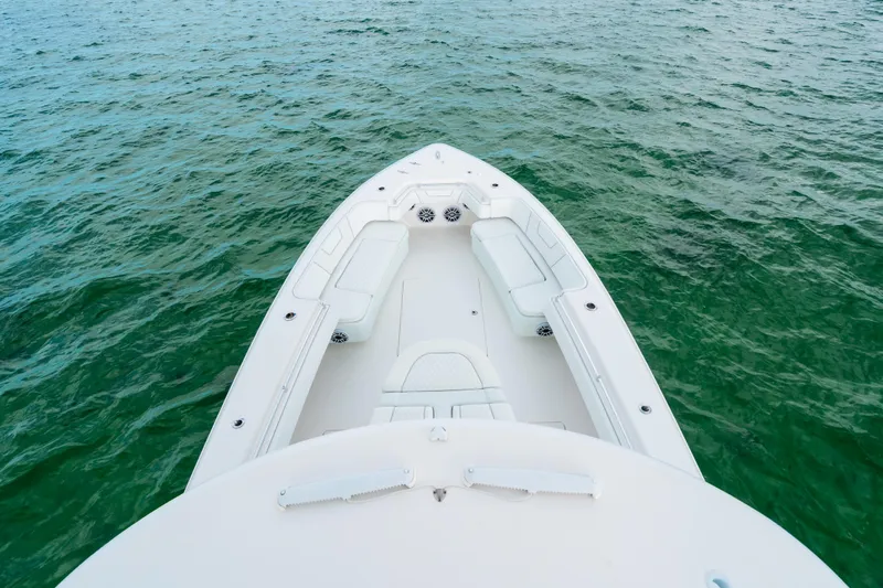 Slide: The Image of 2021 Contender 44 ST boat on calm green water, showcasing spacious deck seating. - 29