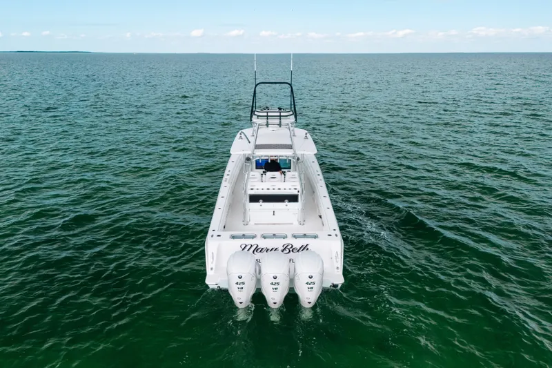 Slide: The Image of 2021 Contender 44 ST boat on open water, rear view with triple engines. - 8