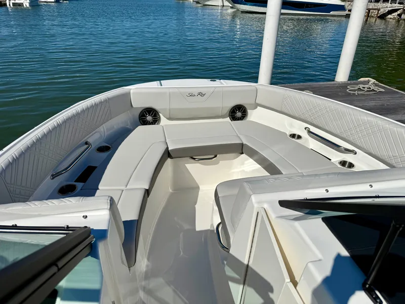 Slide: The Image of The image shows the cockpit of a 2026 Sea Ray SDX 230 Outboard. It features white upholstery and cup holders. - 9