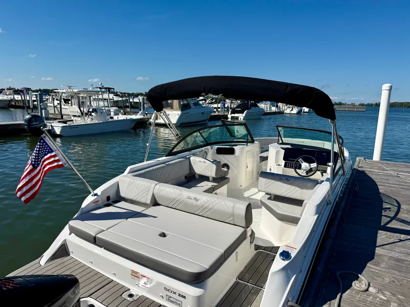 Slide: The Image of The 2026 Sea Ray SDX 230 Outboard is docked. It features a sleek design and spacious seating. - 3