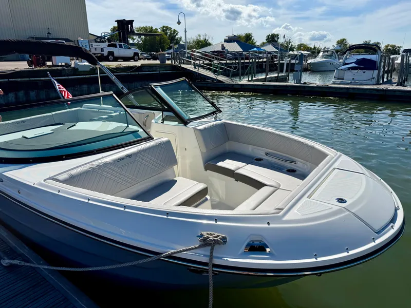 Slide: The Image of A 2026 Sea Ray SDX 230 Outboard docked. It features white upholstery and an open deck. - 14