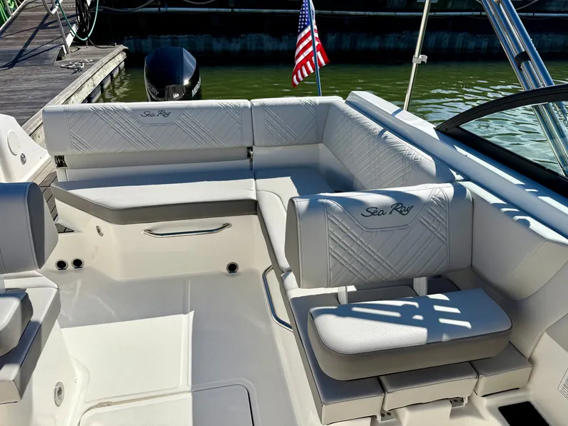 Slide: The Image of The image shows the cockpit of a Sea Ray SDX 230 Outboard with white upholstery and a US flag. - 11