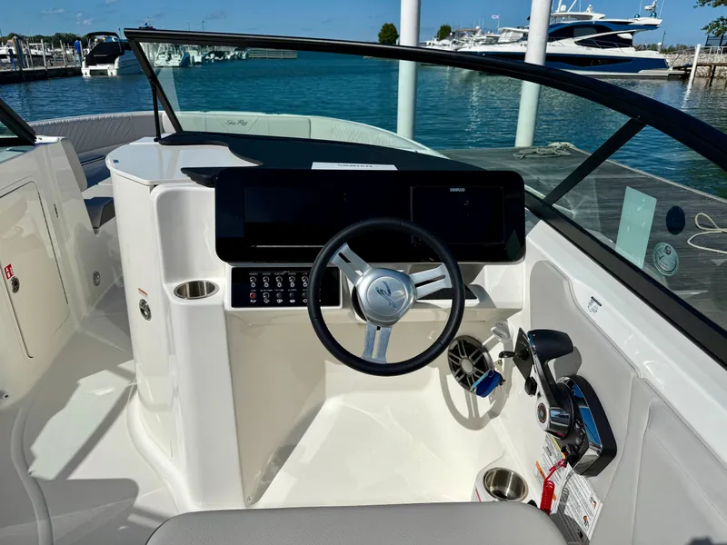 Slide: The Image of The image shows the cockpit of a 2026 Sea Ray SDX 230 Outboard with modern steering and instruments. - 4