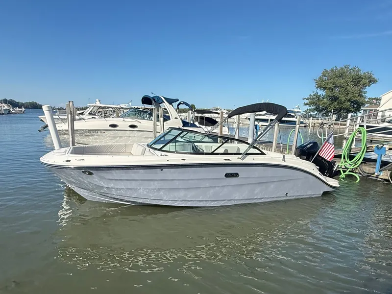 Slide: The Image of A 2026 Sea Ray SDX 230 Outboard is docked in the water. - 2