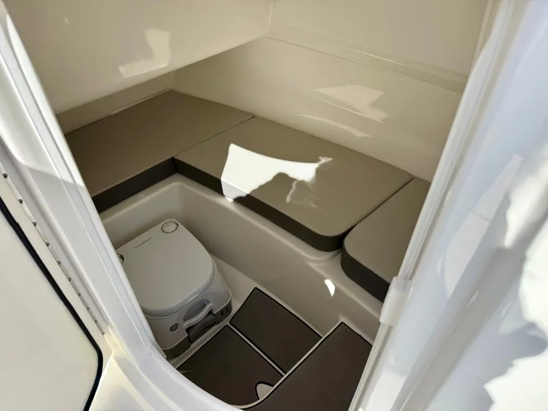 Slide: The Image of Interior of the 2026 Sea Ray SDX 230 Outboard with cushioned seating and a portable toilet. - 8
