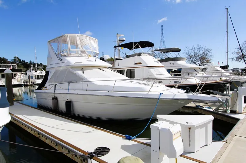 Slide: The Image of 1989 Sea Ray 345 Sedan Bridge yacht docked at marina under clear blue sky. - 2