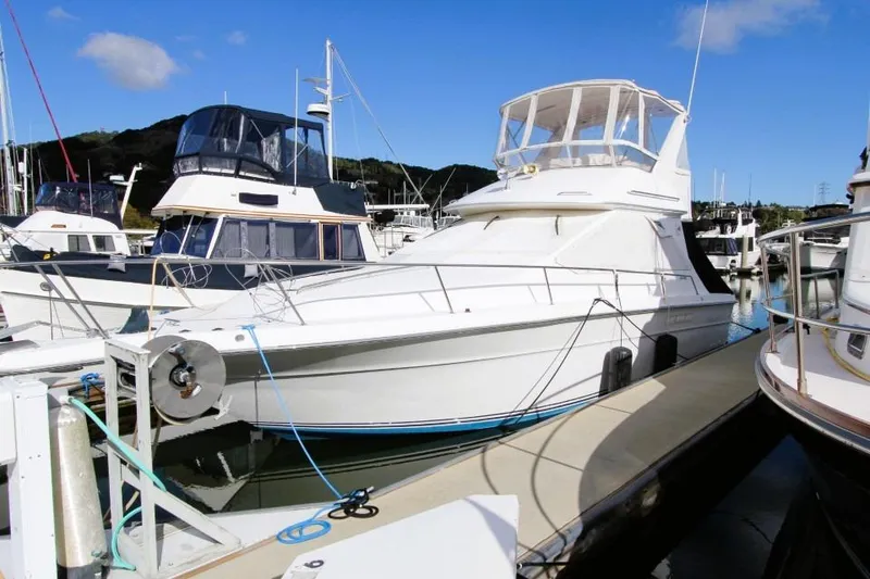 Slide: The Image of 1989 Sea Ray 345 Sedan Bridge yacht docked at marina under clear blue sky. - 3