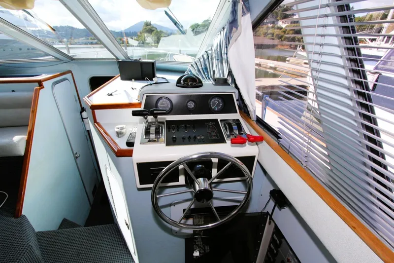 Slide: The Image of 1989 Sea Ray 345 Sedan Bridge helm with steering wheel and control panel. - 6