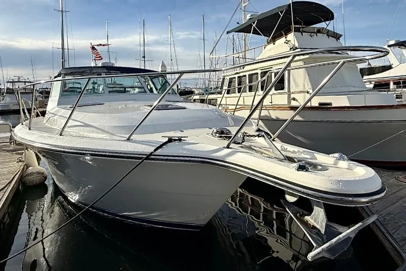 Slide: The Image of 1990 Tiara Yachts 3600 Open docked at marina, showcasing sleek design and sturdy build. - 1