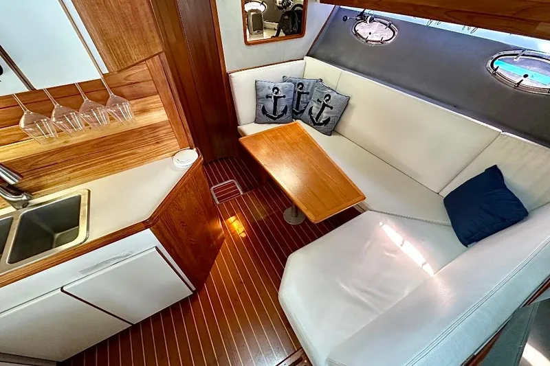 Slide: The Image of Luxurious 1990 Tiara Yachts 3600 Open interior with cozy seating and elegant wood finishes. - 10