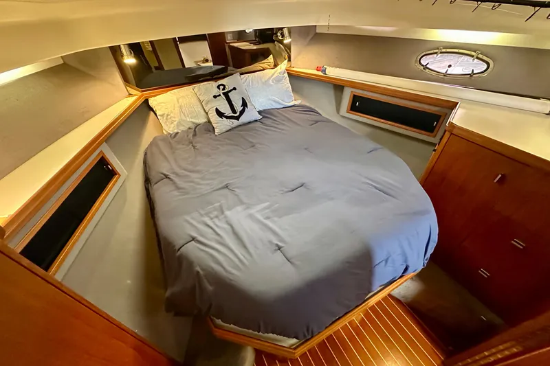 Slide: The Image of Cozy cabin interior of 1990 Tiara Yachts 3600 Open with anchor-themed bedding. - 12