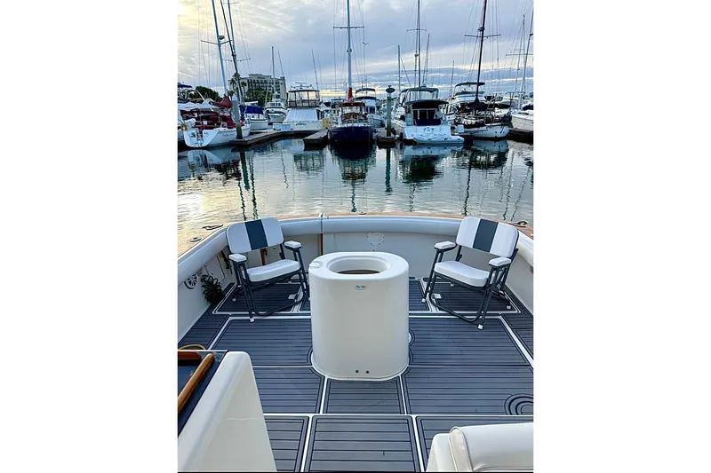 Slide: The Image of 1990 Tiara Yachts 3600 Open at marina, featuring spacious deck and seating. - 20