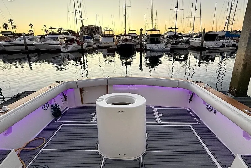 Slide: The Image of 1990 Tiara Yachts 3600 Open at marina during sunset, featuring illuminated deck. - 22