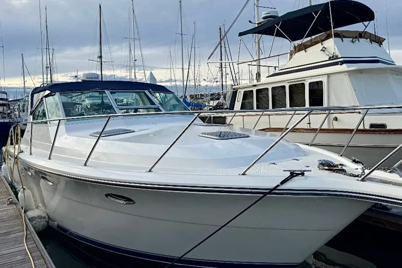 Slide: The Image of 1990 Tiara Yachts 3600 Open docked at marina, surrounded by sailboats. - 27