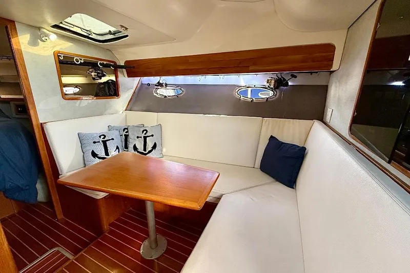 Slide: The Image of Cozy interior of 1990 Tiara Yachts 3600 Open with white seating and nautical decor. - 8