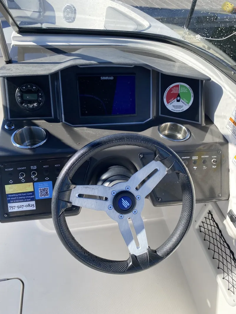 Slide: The Image of 2024 Bayliner VR6 boat dashboard with steering wheel and control panel. - 4