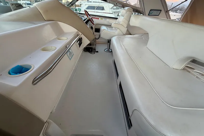 Slide: The Image of 1997 Sea Ray 500 Sundancer interior with white seating and helm area. - 10
