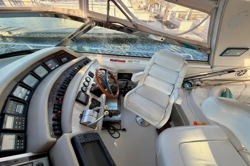 Slide: The Image of Cockpit of 1997 Sea Ray 500 Sundancer with steering wheel and control panels. - 11