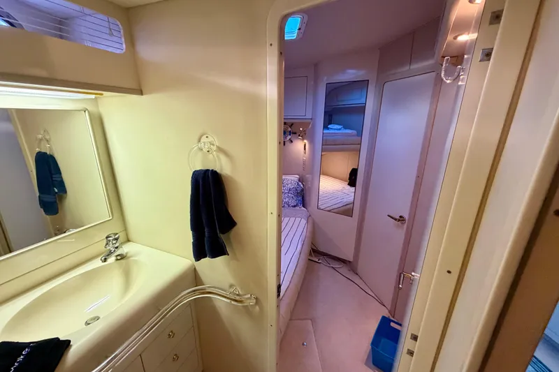 Slide: The Image of Interior of 1997 Sea Ray 500 Sundancer yacht, featuring bathroom and cozy bedroom. - 18